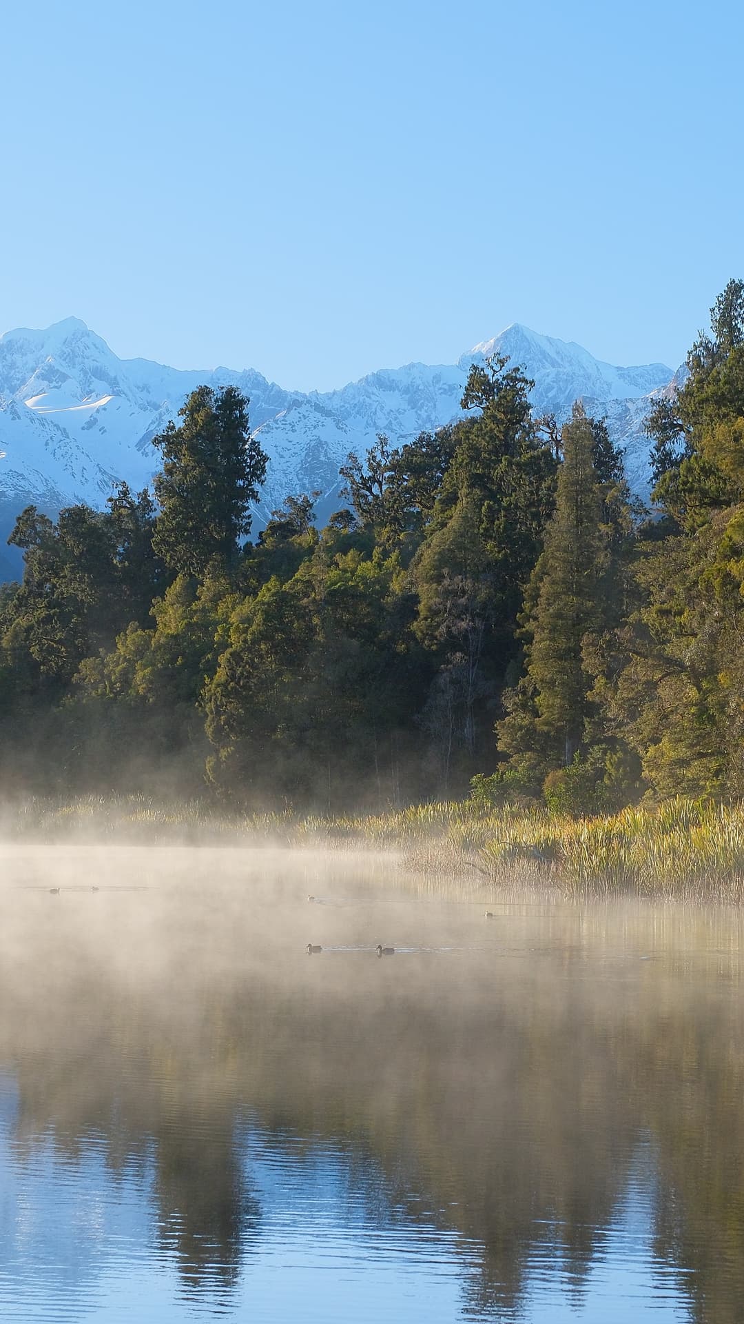 Morning mist over a still mountain lake